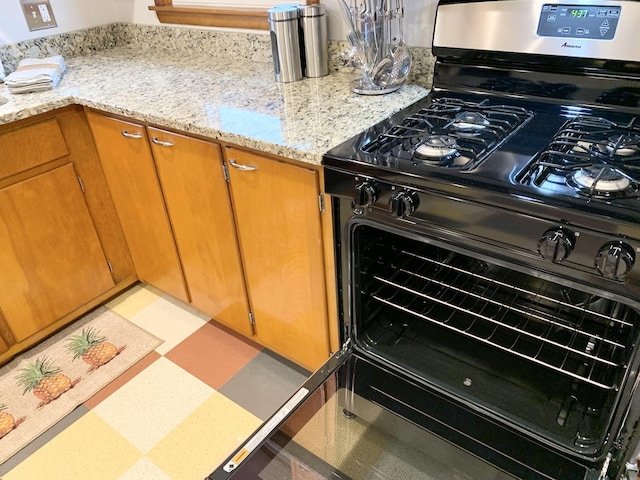 kitchen with light stone counters and black range with gas cooktop