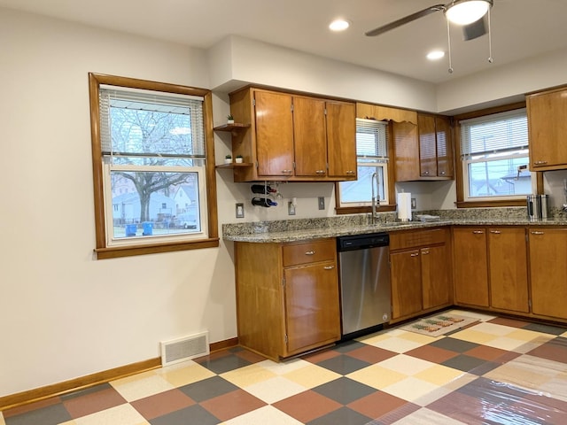 kitchen with light stone countertops, stainless steel dishwasher, and ceiling fan