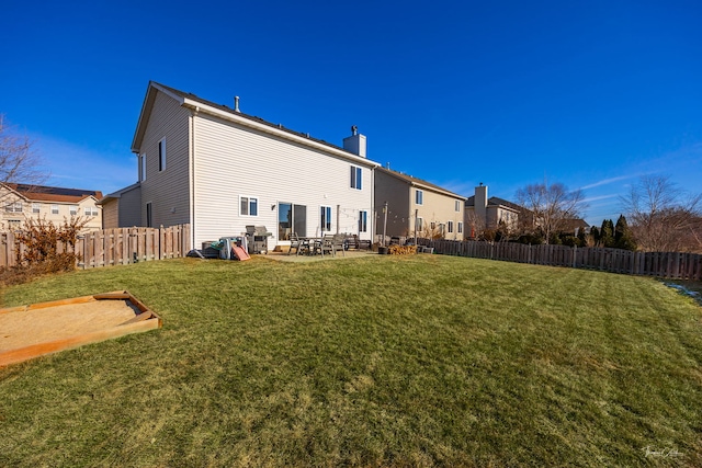 rear view of property featuring a yard and a patio area