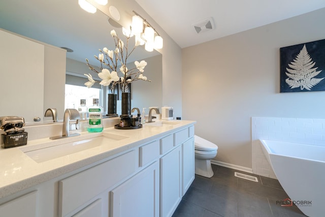 bathroom featuring a washtub, vanity, tile patterned floors, toilet, and a chandelier