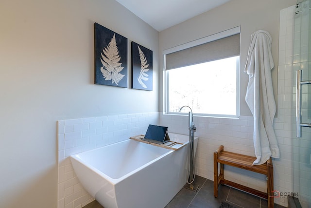 office area featuring dark tile patterned flooring and tile walls