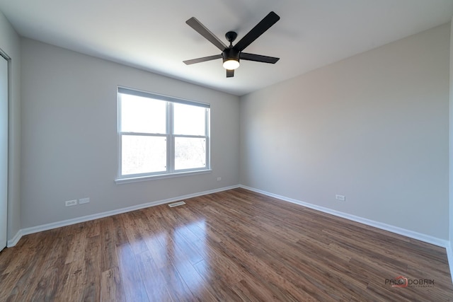 unfurnished room with ceiling fan and dark hardwood / wood-style flooring