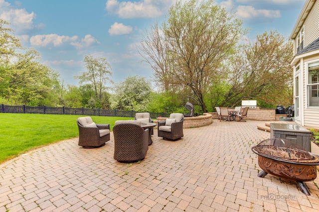 view of patio with an outdoor living space with a fire pit