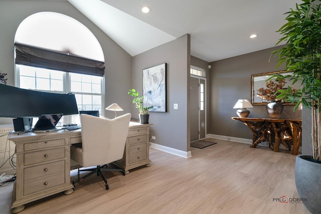 office space featuring vaulted ceiling, plenty of natural light, and light hardwood / wood-style floors