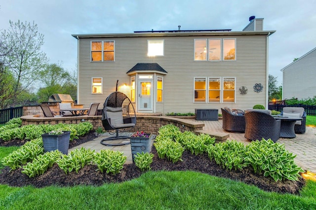 rear view of property with a patio, outdoor lounge area, and solar panels