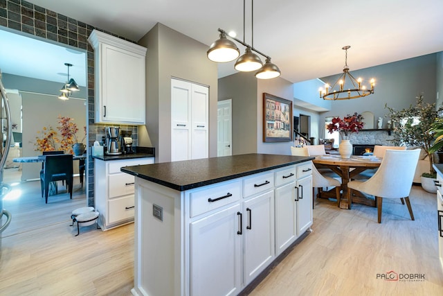 kitchen featuring pendant lighting, light hardwood / wood-style floors, a kitchen island, and white cabinets