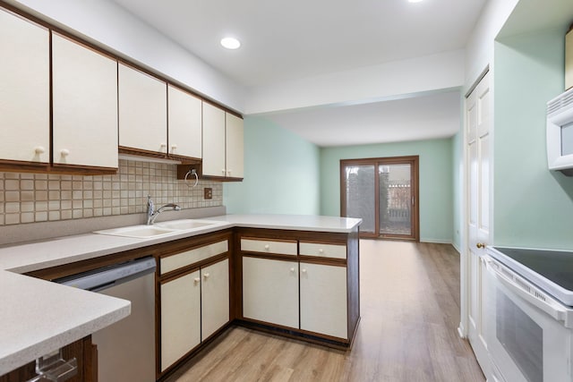 kitchen with white electric range, sink, backsplash, stainless steel dishwasher, and light wood-type flooring