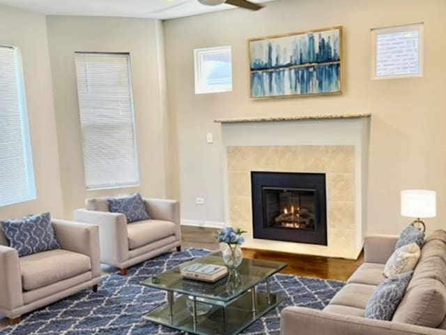 living room with ceiling fan, a fireplace, and dark hardwood / wood-style flooring