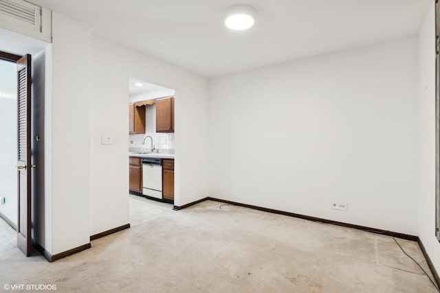 empty room featuring sink and light colored carpet