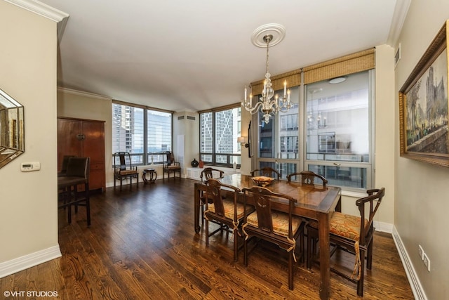 dining room featuring dark wood-type flooring, ornamental molding, and a notable chandelier