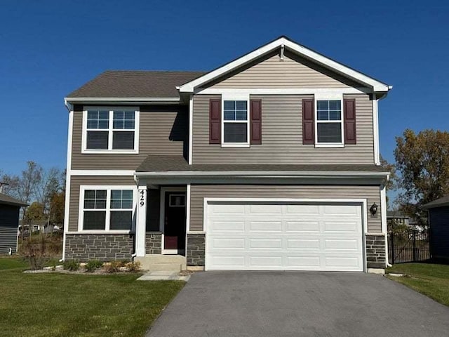 view of front of home with a garage and a front lawn