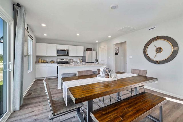 dining space with wood-type flooring