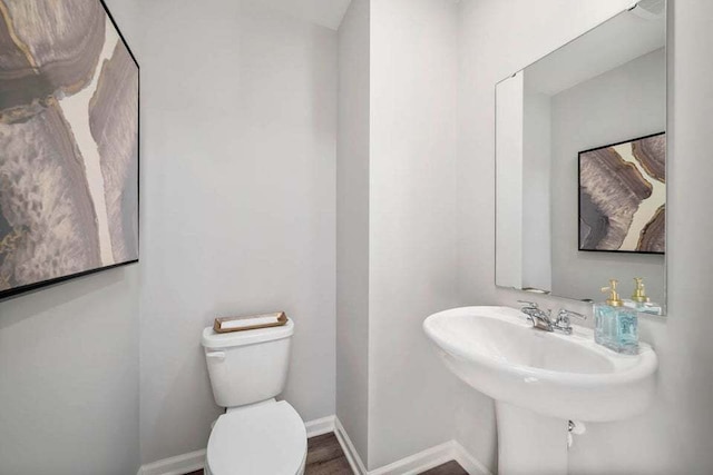 bathroom featuring hardwood / wood-style floors and toilet