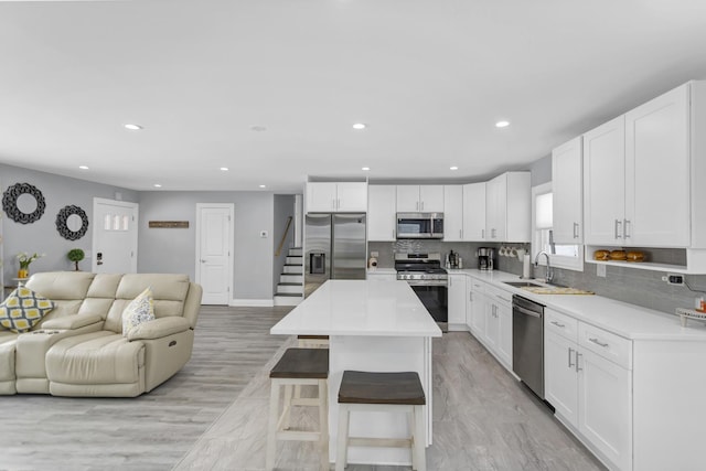 kitchen with stainless steel appliances, a center island, and white cabinets