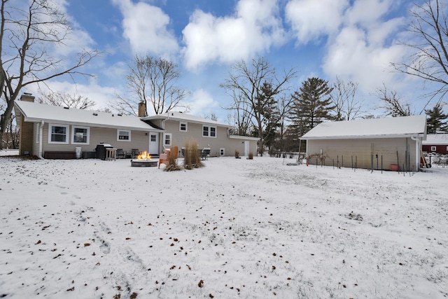 snow covered property with an outdoor fire pit