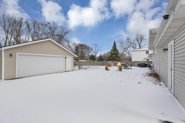 yard layered in snow with a garage and an outdoor structure