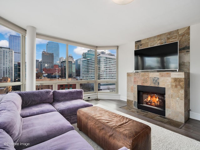 living room featuring a wall of windows, hardwood / wood-style floors, and a tile fireplace