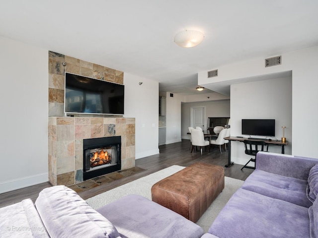 living room with dark hardwood / wood-style floors and a tile fireplace