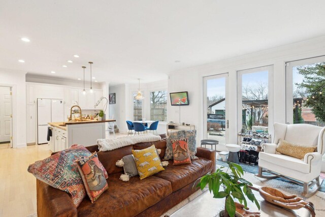 living room featuring a premium fireplace, a wealth of natural light, and crown molding