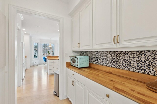 kitchen with wood counters, white appliances, a wealth of natural light, and white cabinets