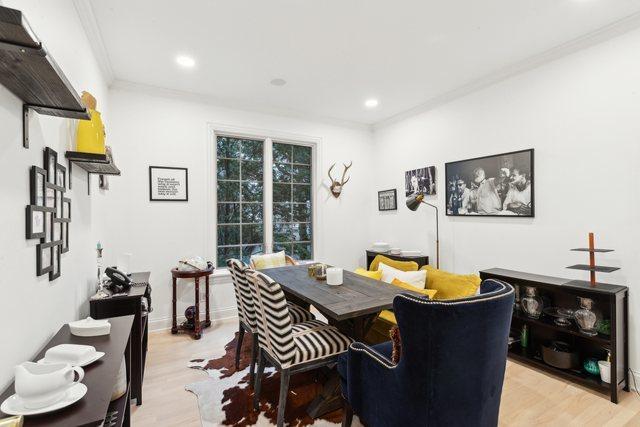 interior space featuring pendant lighting, wooden counters, white cabinets, decorative backsplash, and light wood-type flooring