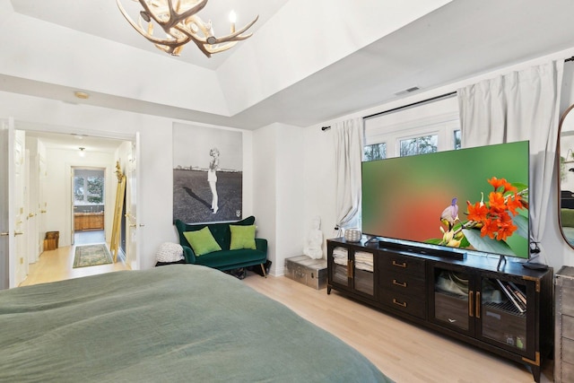 bedroom with a chandelier and light wood-type flooring