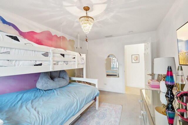 bedroom with light colored carpet and a chandelier