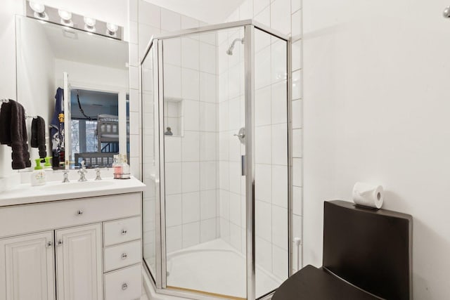 bathroom featuring a shower with door and vanity