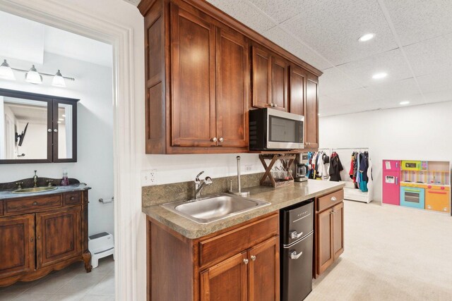 kitchen with sink, a center island, light carpet, and a kitchen breakfast bar