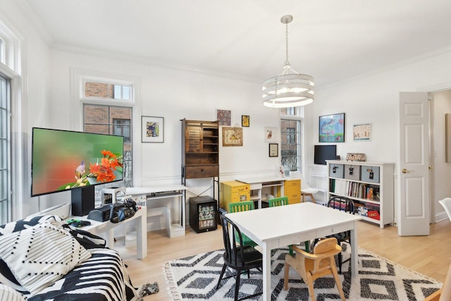 dining area featuring a notable chandelier, ornamental molding, and light wood-type flooring