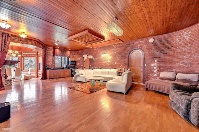 living room featuring hardwood / wood-style floors, wooden ceiling, and brick wall