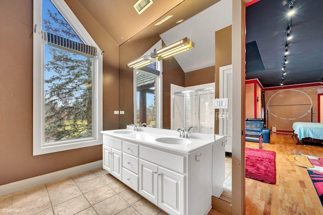 bathroom featuring walk in shower, lofted ceiling, and vanity