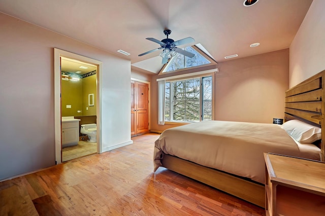 bedroom featuring ceiling fan, lofted ceiling, connected bathroom, and light hardwood / wood-style floors