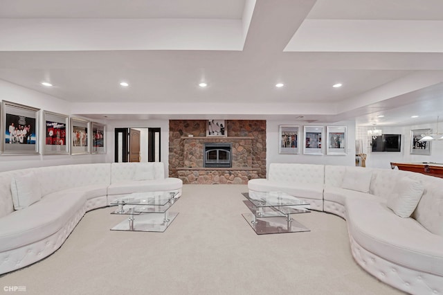 living room featuring a stone fireplace and carpet