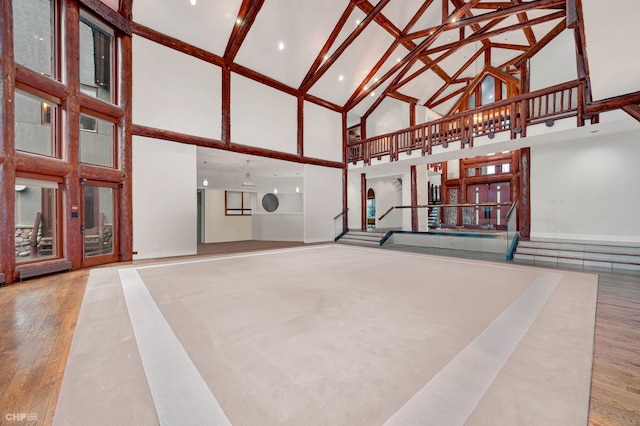 interior space with high vaulted ceiling and hardwood / wood-style floors