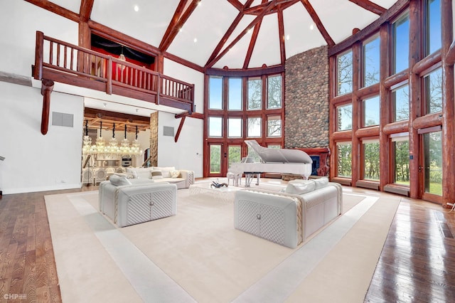 unfurnished living room with beamed ceiling, hardwood / wood-style floors, and a high ceiling