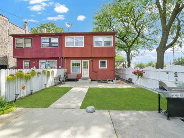 back of property featuring a patio area and a lawn