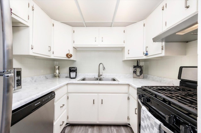 kitchen featuring dishwasher, gas stove, sink, and white cabinetry