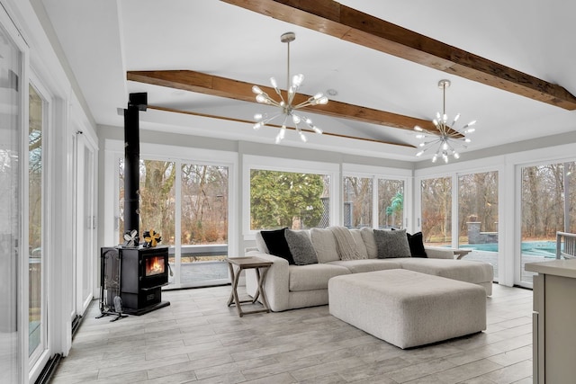 sunroom / solarium with an inviting chandelier, beam ceiling, and a wood stove