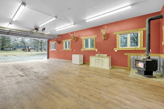 garage with a garage door opener and a wood stove