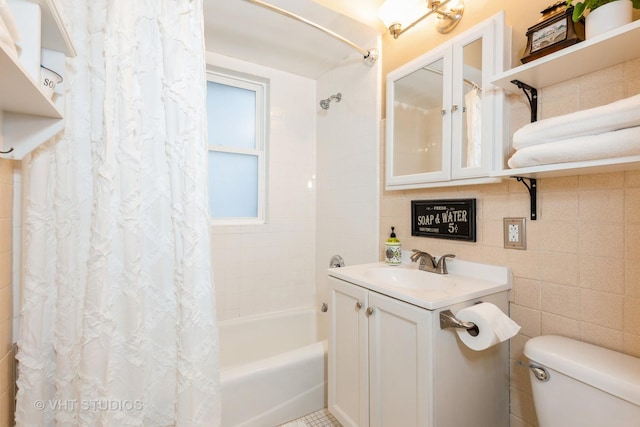 full bathroom with vanity, tile walls, shower / bath combo with shower curtain, and toilet