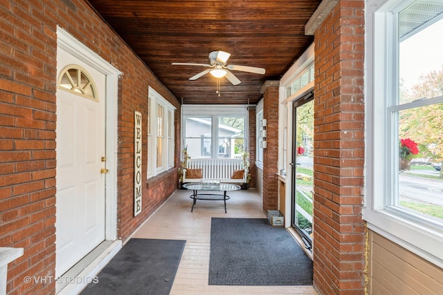 unfurnished sunroom with wood ceiling, ceiling fan, and a wealth of natural light