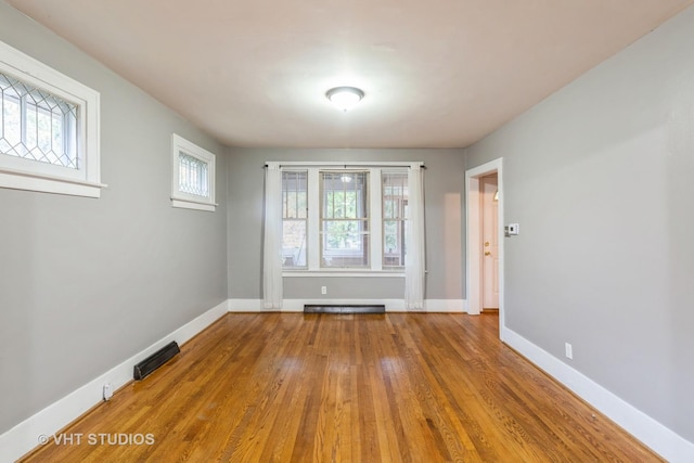 empty room featuring a baseboard heating unit and hardwood / wood-style floors