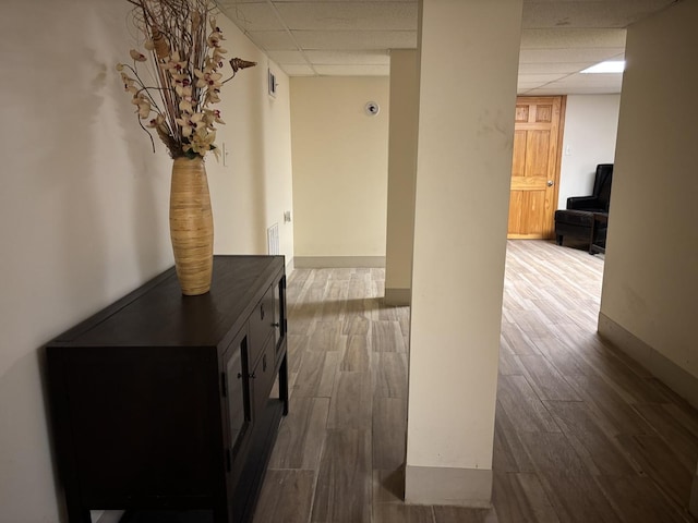 hallway with hardwood / wood-style flooring and a drop ceiling