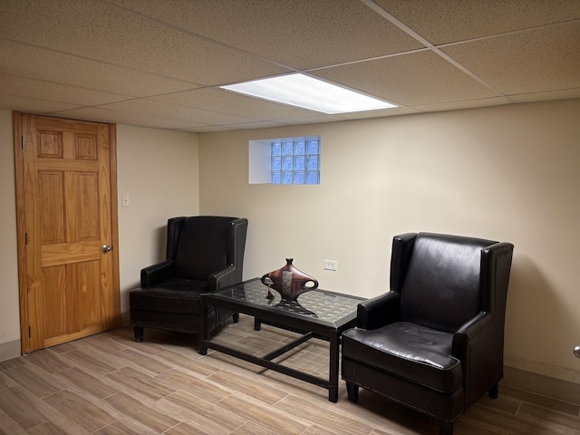 living area featuring hardwood / wood-style flooring and a paneled ceiling