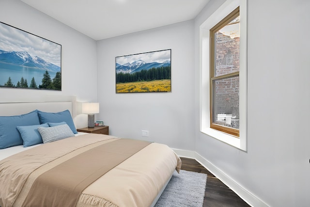 bedroom featuring dark hardwood / wood-style flooring and multiple windows