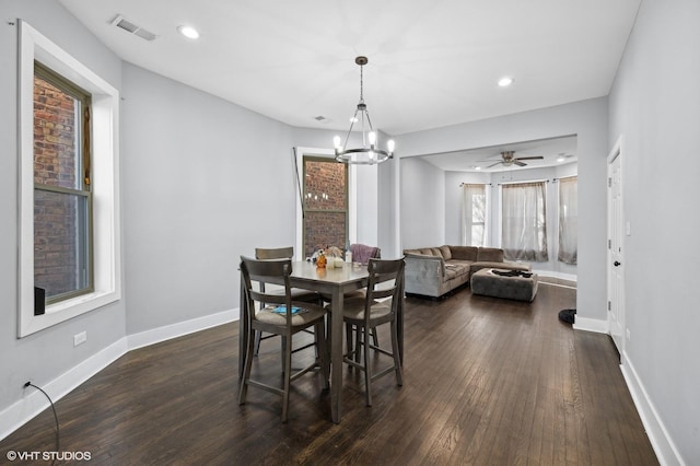 dining area with dark wood-type flooring and a notable chandelier