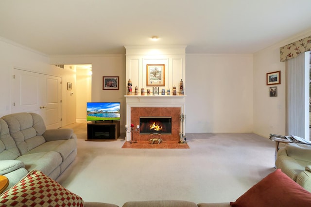 living room with a tiled fireplace, crown molding, and light carpet