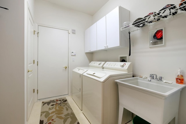 laundry room with independent washer and dryer, cabinets, sink, and light tile patterned floors