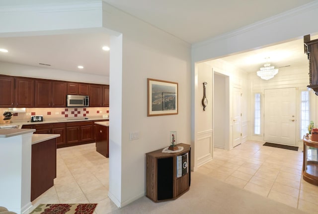 kitchen featuring ornamental molding, light tile patterned floors, backsplash, and black electric cooktop